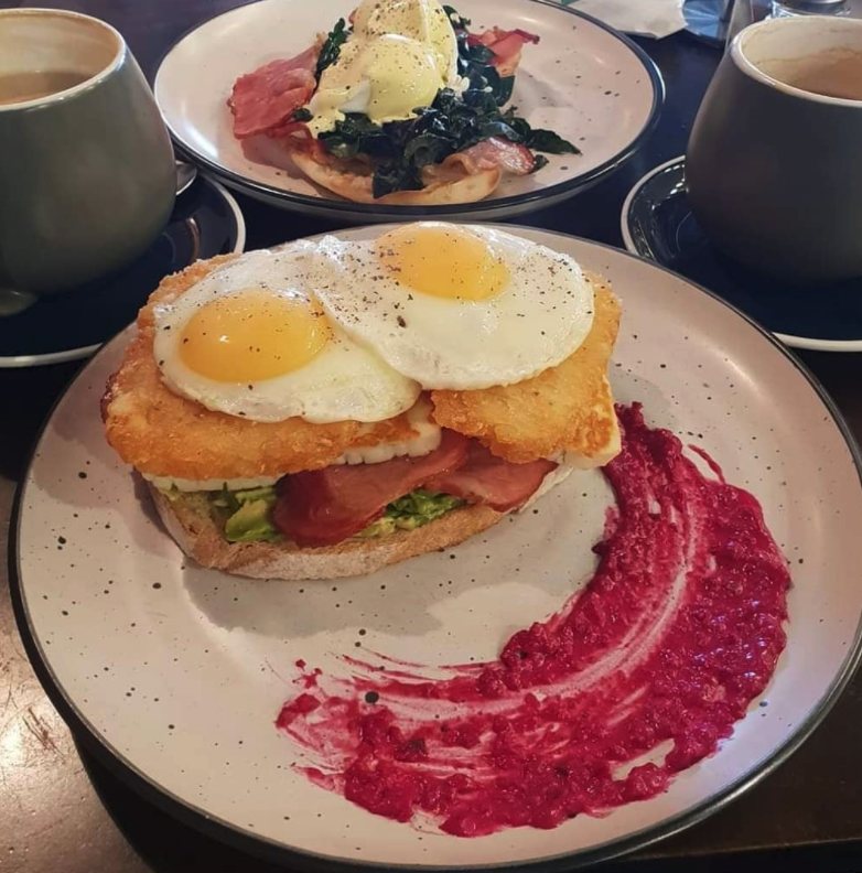Avocado stack with two fried eggs on a hash brown